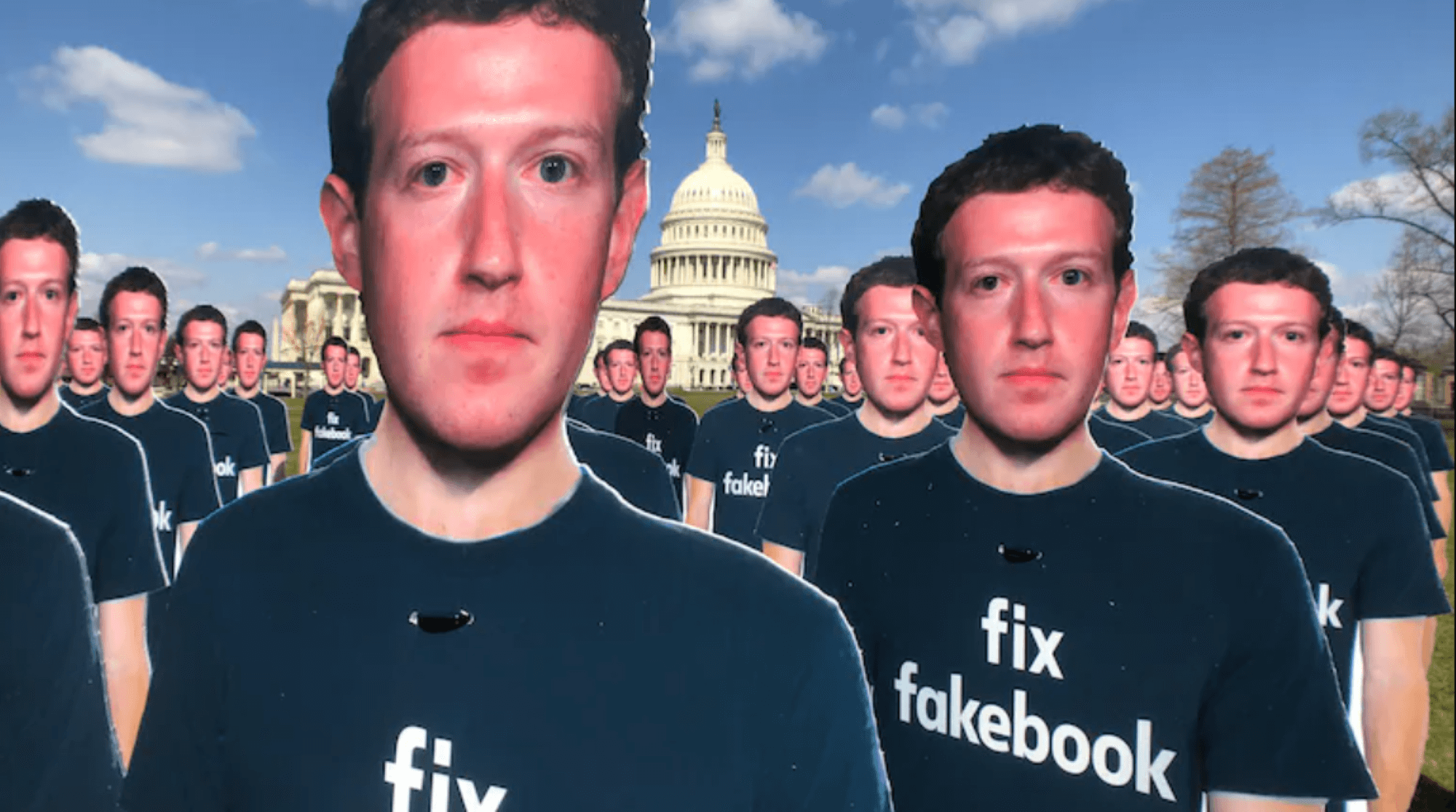cut-outs of Mark Zuckerberg are lined up in front of the US Capitol building on sunny day like a creepy army. Each of the cutouts has the words "fix facebook" on their t-shirts.