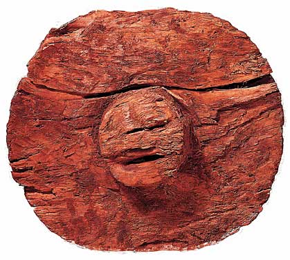round red stone with what looks like a face, etched into a perfectly round protusion.