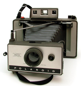 A vintage handheld camera, with an accordion style telescopic lens. 